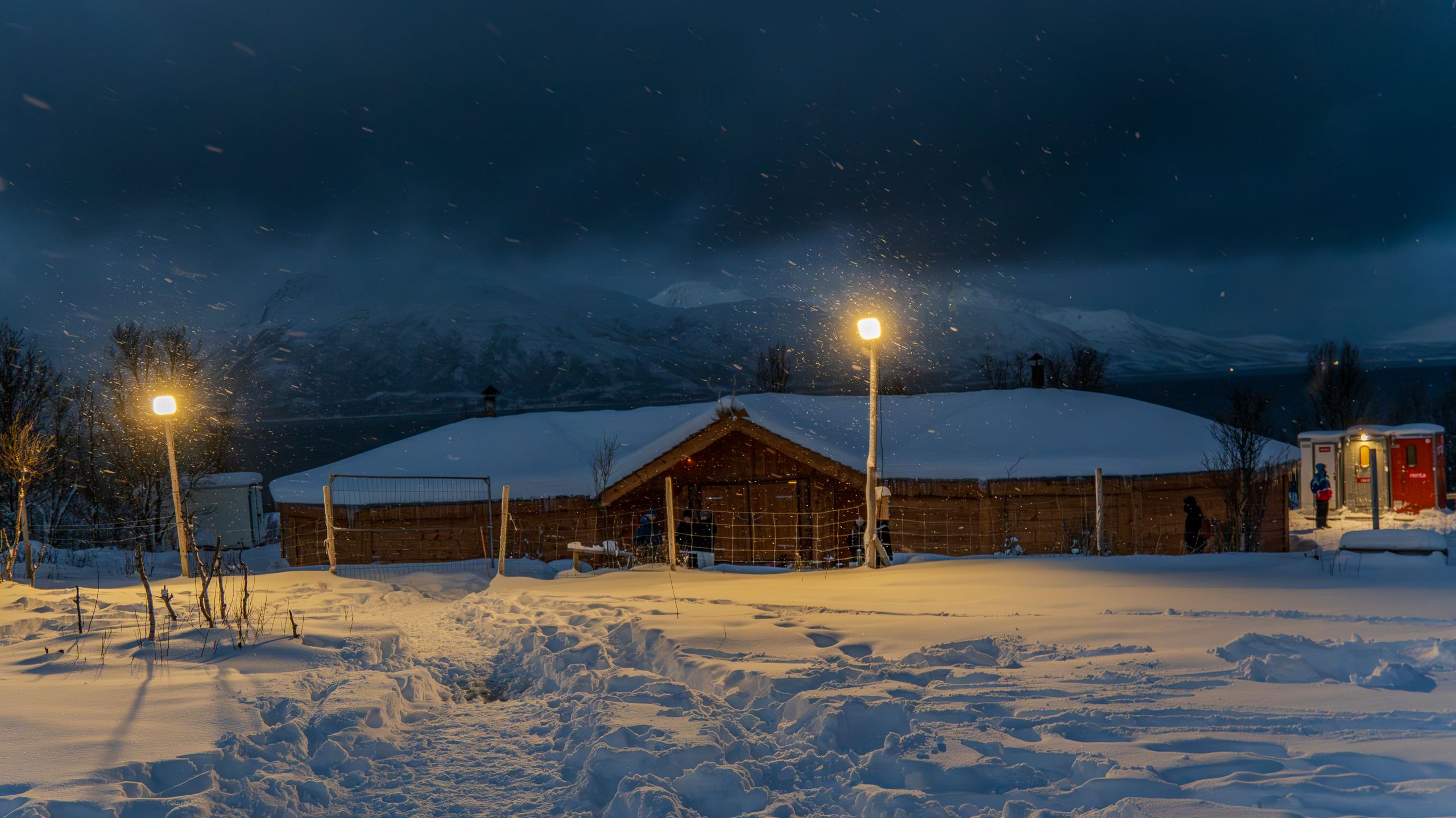 Schneebedeckte Blockhütte im Zwielicht beleuchtet