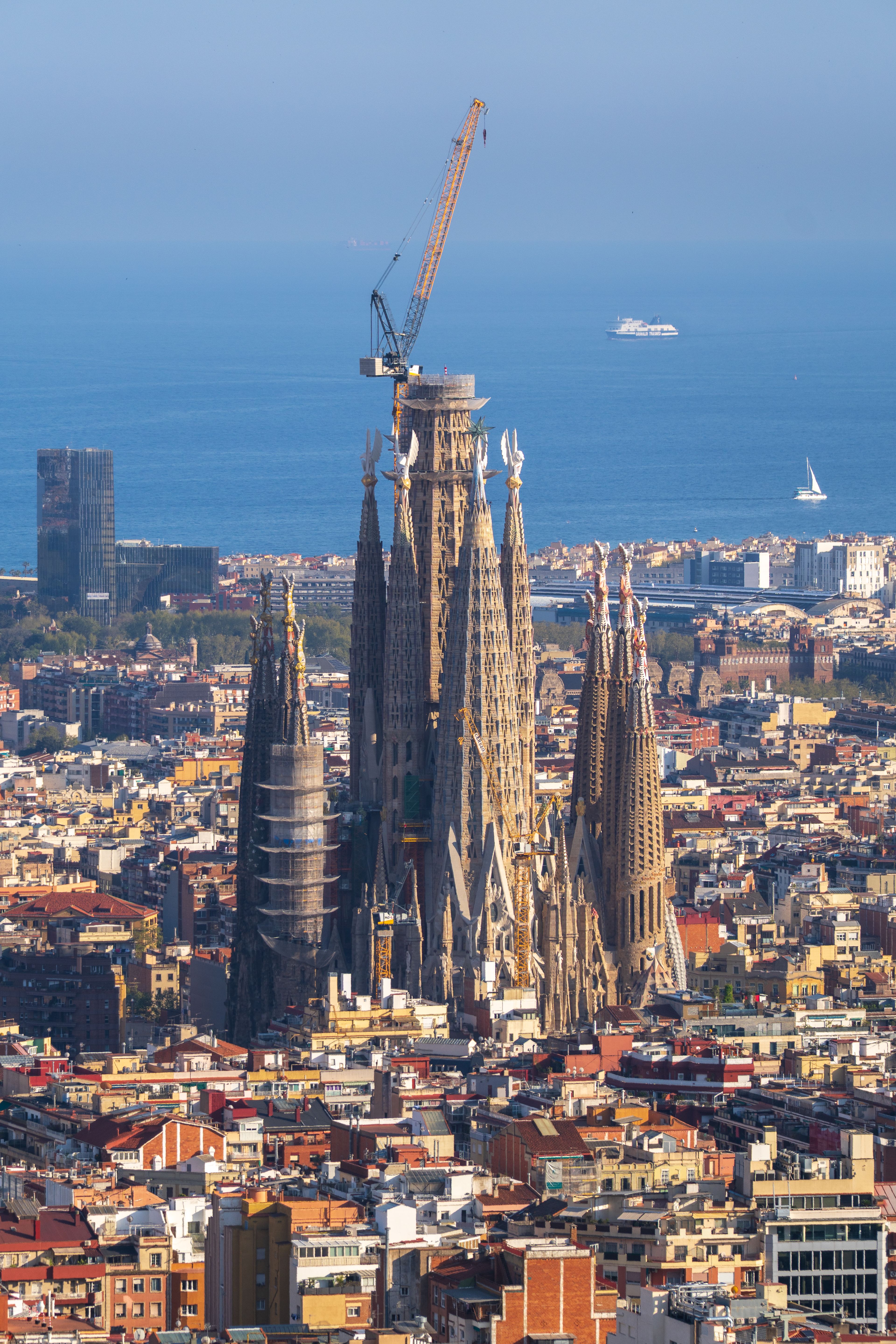 Sagrada Família and the city from a hilltop with ships on the horizon